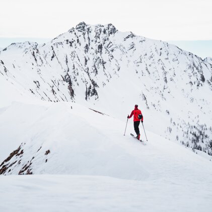 Skier in red jacket on snow-covered mountain | © ATOMIC