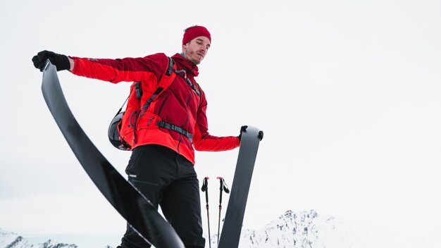 Man with skis in the mountains | © ATOMIC