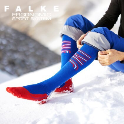 Blaue und rote Skisocken von Falke im Schnee. | © FALKE