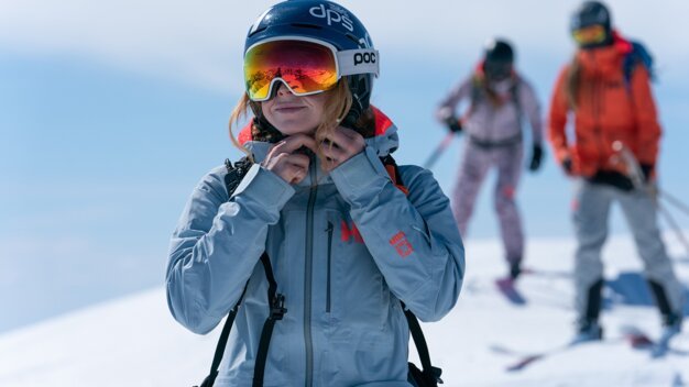 Skier fastening their jacket in the mountains. | © Helly Hansen / Cam McLeod