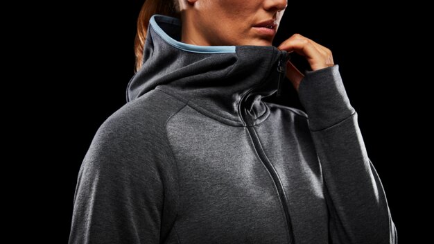 Frau trägt grauen Hoodie mit blauem Kragen | © Helly Hansen
