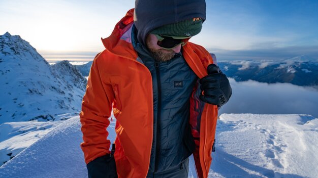 Man in mountain gear on a snowy mountaintop. | © Helly Hansen / Cam McLeod