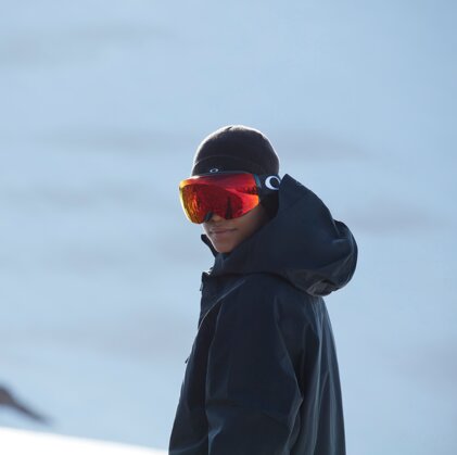 Person wearing ski goggles and beanie in snow | © Oakley