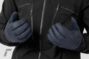 Person mit blauen Handschuhen und schwarzer Jacke. | © Reusch