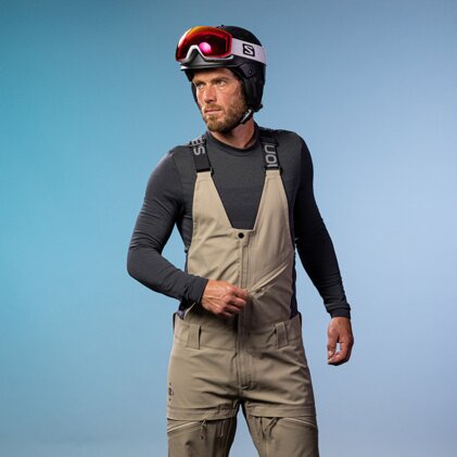 Man wearing ski helmet and bib overalls. | © SALOMON