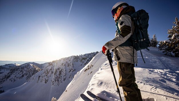 Skifahrer steht auf einem schneebedeckten Berggipfel | © Salomon