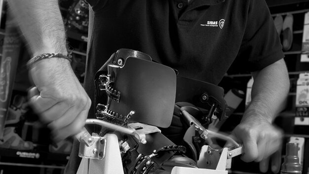 Man adjusting ski boot in a workshop. | © Sidas