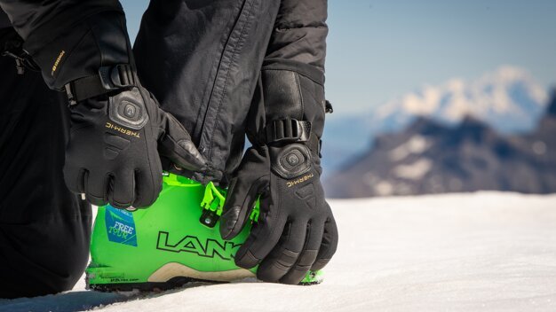 Person bindet Skischuh mit beheizten Handschuhen. | © Focus Outdoor