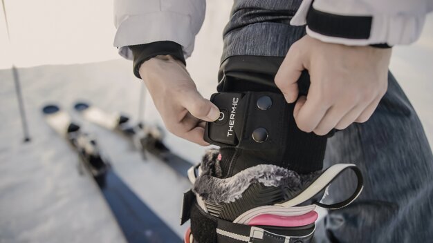 Person befestigt Therm-ic Heizgerät an Skischuh | © Thermic / Loic Schutz