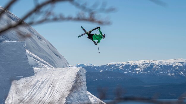 Skier jumping off snow cliff with mountain backdrop. | © VÖLKL / c.Pally-Learmond