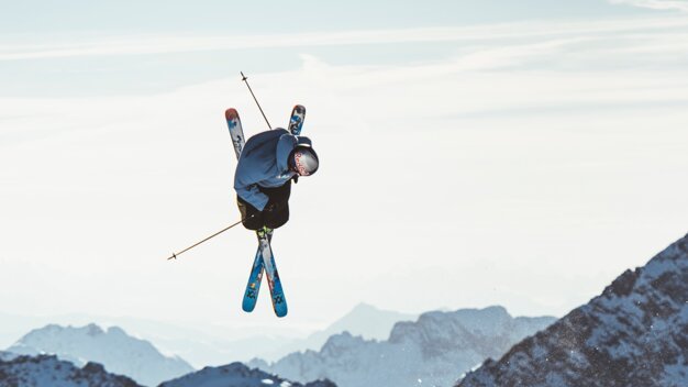 Skier performing jump in mountains. | © VÖLKL / Syo van Vliet