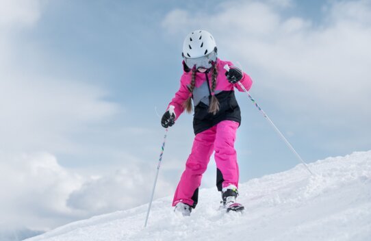 Mädchen beim Skifahren auf einer schneebedeckten Piste. | © McKINLEY