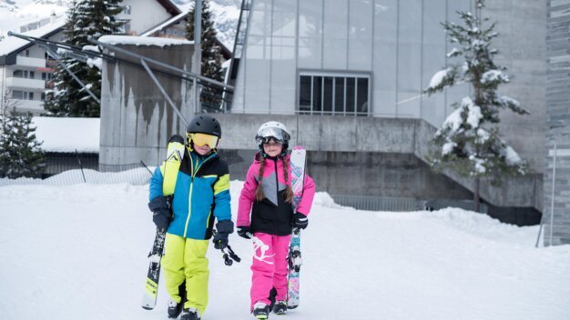 Two children in ski gear standing in the snow. | © McKINLEY