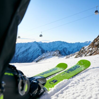 Grüne Skier im Schnee mit Bergblick