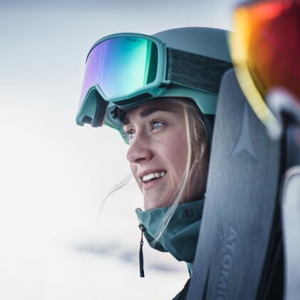 Woman wearing ski helmet and goggles smiling
