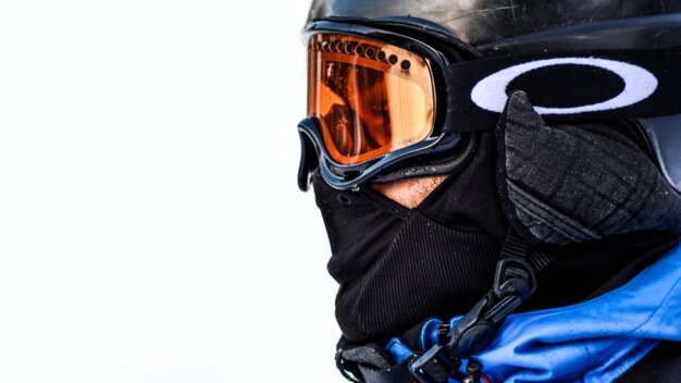 Skier with helmet, goggles, and face mask