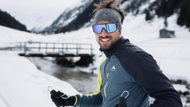 Lächelnder Mann beim Langlaufen in verschneiter Landschaft | © INTERSPORT International Corporation GmbH