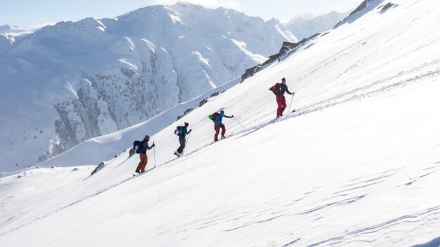 A group of ski mountaineers in a snowy mountain landscape. | © Tim Marcour