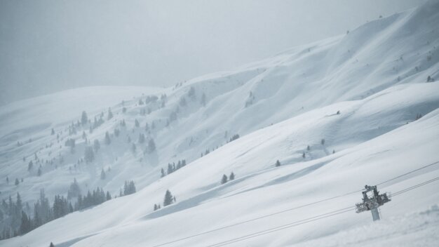 Schneebedeckter Berghang mit Liftstütze | © Tim Marcour