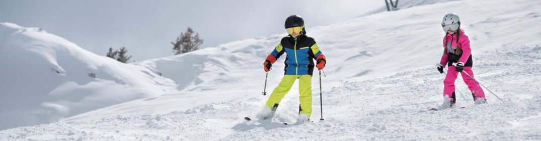 Two children skiing on a snowy slope. | © IIC - INTERSPORT International Corporation GmbH