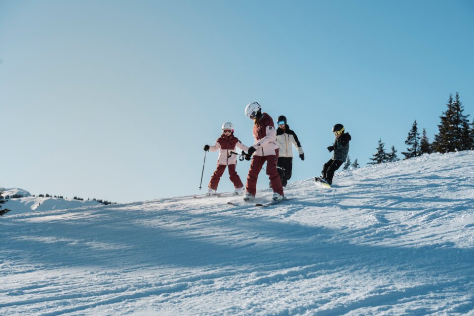 Family skiing and snowboarding on a snowy mountain. | © INTERSPORT International Corporation GmbH