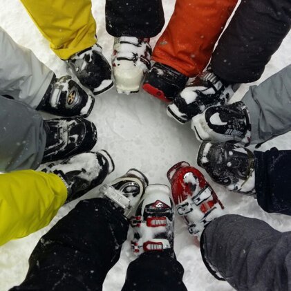 Circle of ski boots in the snow.