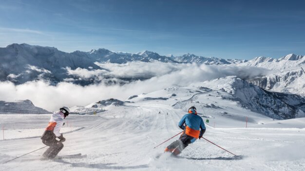 Two skiers on a snowy slope with a mountain backdrop. | © aletscharena.ch / Christian Pfammatter  