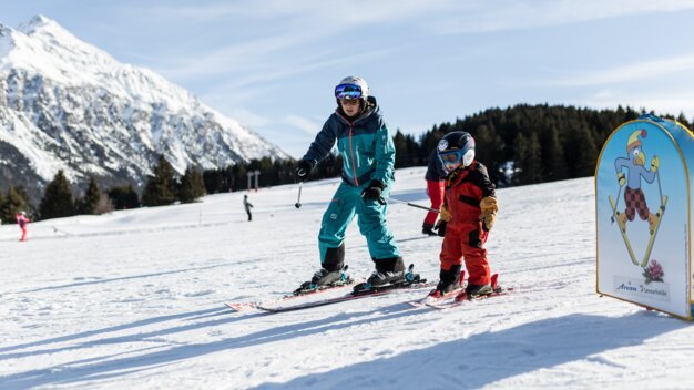 A woman and a child skiing in the mountains. | © Arosa Lenzerheide