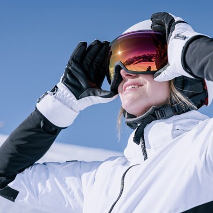 Frau mit Skibrille und Helm im Schnee | © IIC - INTERSPORT International Corporation GmbH
