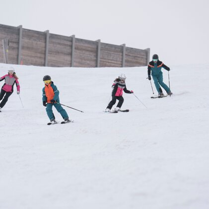 Four skiers on a snowy slope. | © IIC/McKINLEY