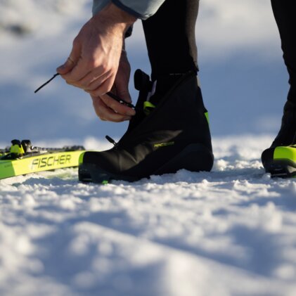 Person schnürt Skischuh im Schnee. | © Fischer Sports GmbH
