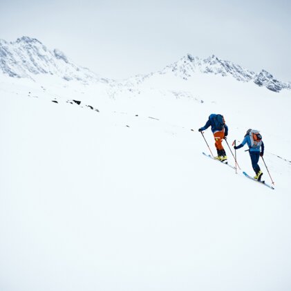 Zwei Skitourengeher steigen einen verschneiten Hang hinauf. | © Fischer Sports GmbH