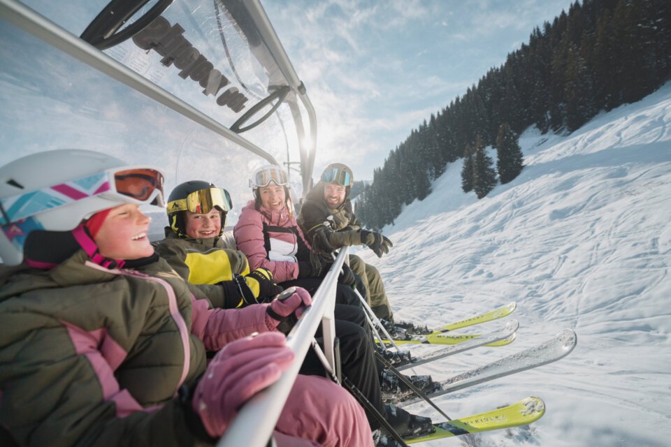 Familie fährt Ski-Lift an einem sonnigen Tag. | © INTERSPORT International Corporation GmbH