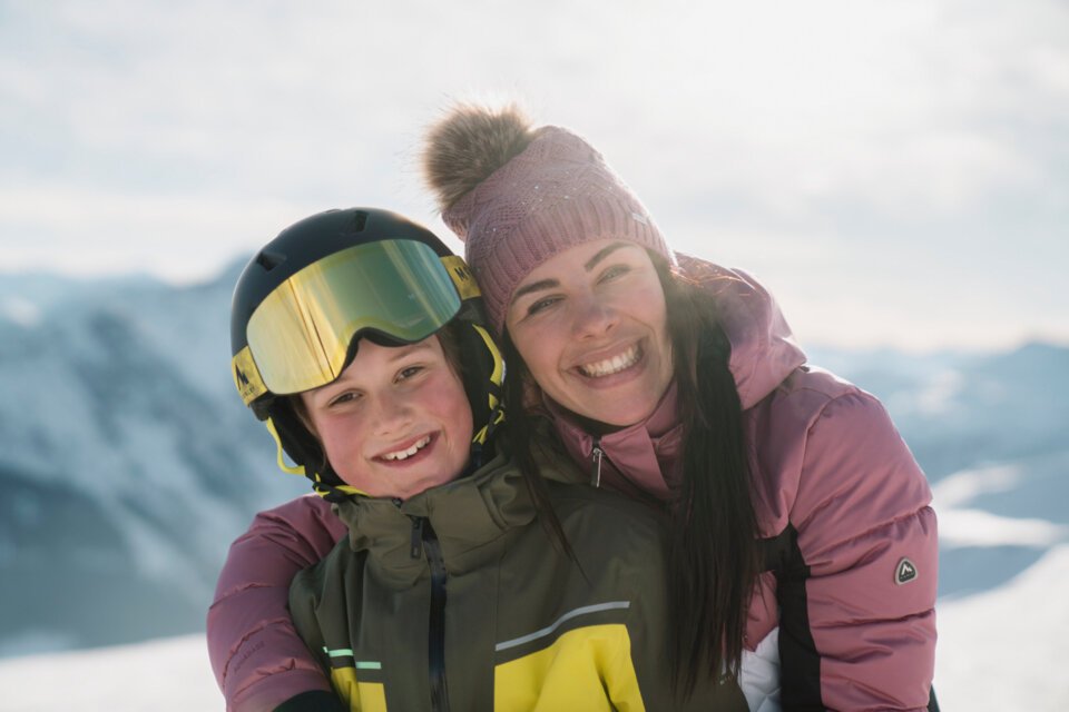 Mutter und Kind beim Skifahren umarmen sich | © INTERSPORT International Corporation GmbH