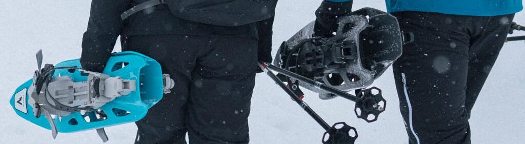 Two people walking in the snow with snowshoes and backpacks. | © IIC/McKINLEY
