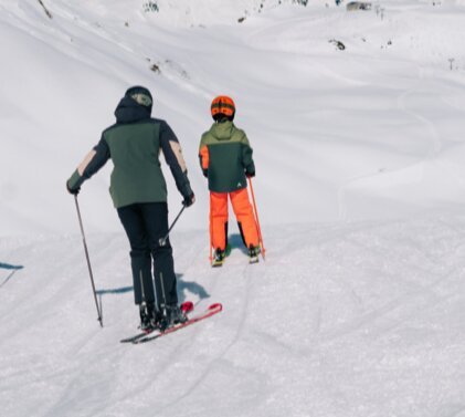 Four people skiing down a ski slope.