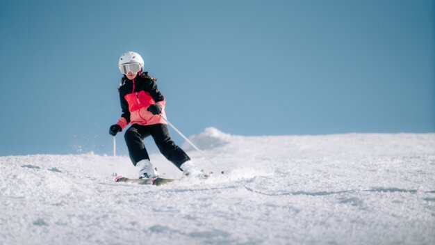 Child skiing down a snowy slope.
