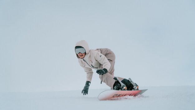 A woman snowboarding in the snow.