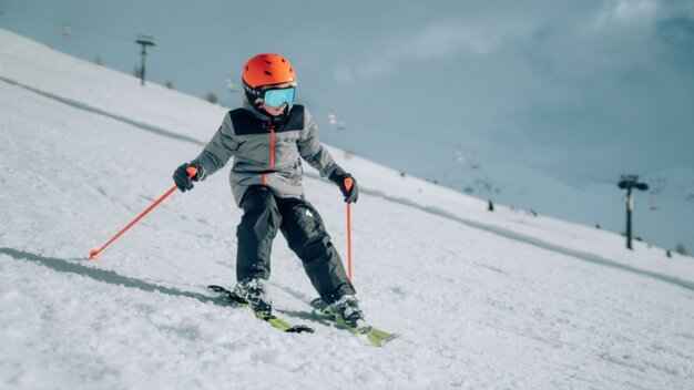 Child skiing on a snowy slope.