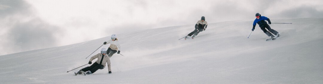 Four skiers on a snowy slope