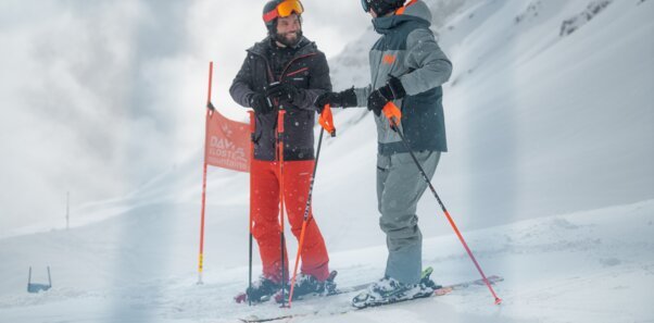 Two skiers conversing in the snow.