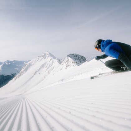 Skier on groomed slope in mountains