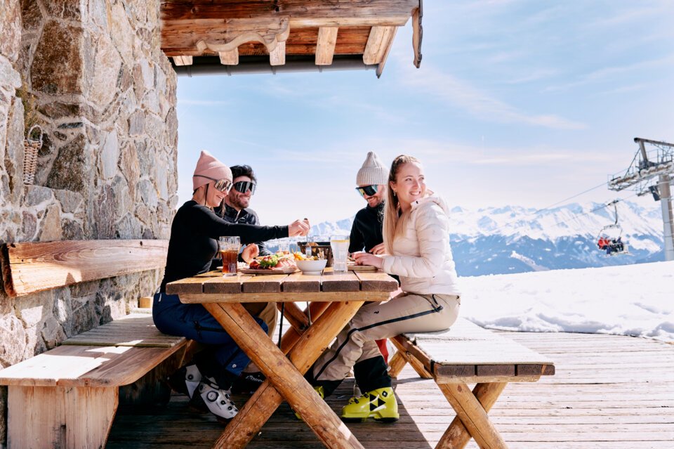 Group of skiers eating at an outdoor table. | © ARMIN WALCHER