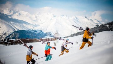 Gruppe von Skifahrern wandert einen schneebedeckten Hang hinauf. | © Weare Merci