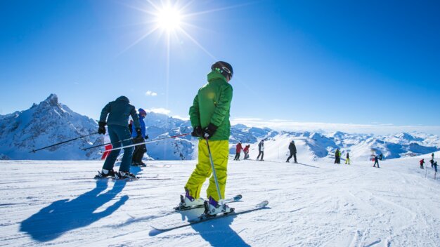 Skiers on a snowy slope on a sunny day. | © Courchevel Tourisme