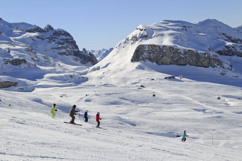 Skiers on a snowy slope with mountains in the background. | © OT Flaine-Monica Dalmasso_flaine-surlespistes-at-otflaine-m.dalmasso