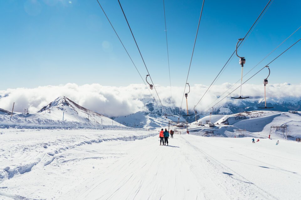 Skiers on a snow-covered slope under a ski lift | © Les 2 Alpes / Luka Leroy