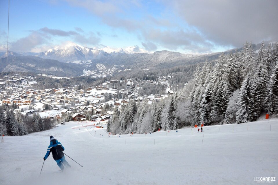 Skieur sur une pente enneigée avec vue sur les montagnes. | © Office de Tourisme Les Carroz