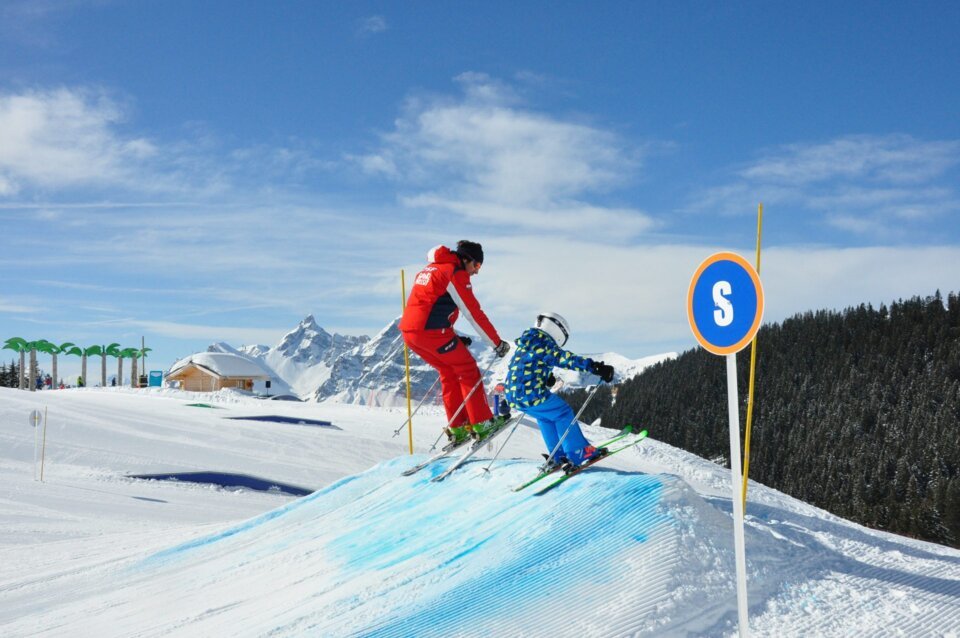 Moniteur de ski et enfant sur la piste | © Office de Tourisme Les Carroz