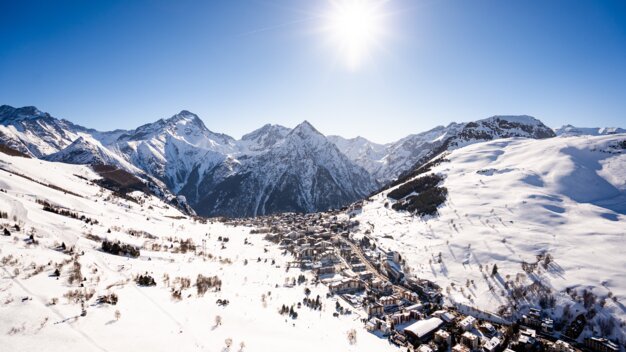 Winter landscape with snow-covered mountains and a village | © Les 2 Alpes / Luka Leroy